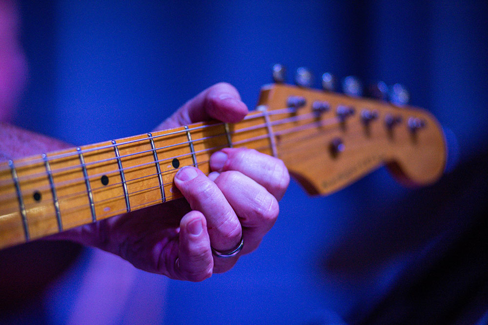 Ein Gitarrist greift auf einer E-Gitarre den Akkord D-Dur