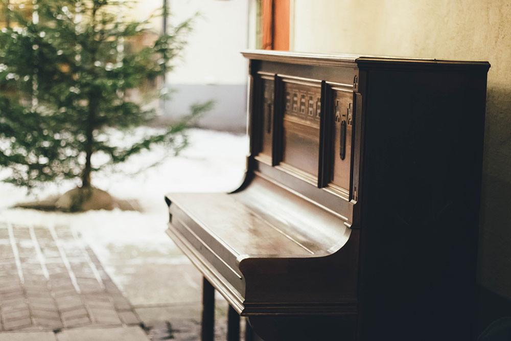 Ein Wandklavier steht an einer Hausmauer